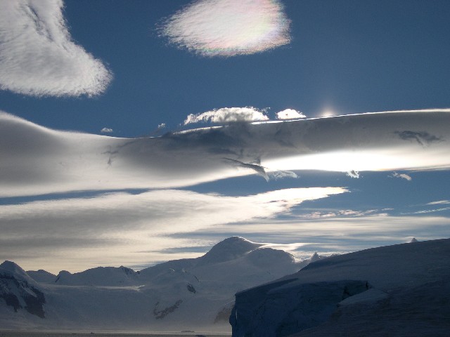 Lenticular clouds showing irisation,
with a weak sun pillar
